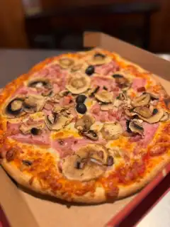 Pizza Reine artisanale garnie de jambon, champignons frais et olives noires, présentée dans sa boîte prête à emporter de la pizzeria Chez Matteo au Porge.
